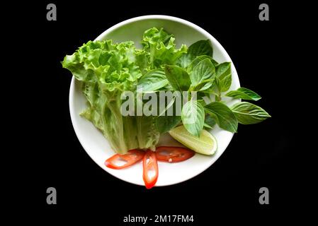 Teller mit vietnamesischen Blättern und Limette für Suppe oder Suppe Pho-Gerichte mit Blick von oben Stockfoto