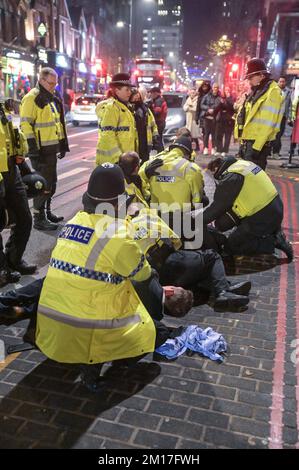 Broad Street, Birmingham, 10. 2022. Dezember – Dies war der dramatische Moment, in dem zwei Männer, die ursprünglich aus dem Reflex-Nachtclub geworfen wurden, von Offizieren bis auf den Boden angegriffen wurden, nachdem sie sich auf die Feiernden zugewandt hatten, die sich anstellten, um reinzukommen. Jemand im Melee konnte hören, wie er sagte: "Er beißt mich" Polizisten aus West Midlands stiegen am Samstag, dem 10. Dezember Abend, schnell auf den Vorfall in der Broad Street ab. Einer der Täter war blutverschmiert und beide wurden in abwartende Polizeiwagen gefesselt. Die Nacht begann ruhig aufgrund der Niederlage von 2-1 gegen Frankreich. Einige Partygänger wurden gesehen Stockfoto