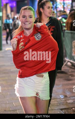 Broad Street, Birmingham, 10. 2022. Dezember - die Nacht, in der England besiegt wurde, wurde von vielen Feiern auf der Broad Street in Birmingham genossen, obwohl Francing 2-1 gegen England gewann. Einige Partygänger wurden auf dem Nachtclub-Strip gesehen, aber einige posierten gerne für ein Foto. Ein Mädchen sagte, sie „bedauere“ es, keinen Mantel zu tragen, da sie mit ihren Armen in einem roten englischen Hemd gesehen wurde, während sie zwischen Clubs ging, bevor sie mit ihrem Freund für ein Foto posierte. Eine Frau wurde jedoch auf einer Trage von einer Sankt-Johns-Krankenwagenmannschaft weggefahren, nachdem sie von Offizieren betreut wurde, weil sie untätig war Stockfoto