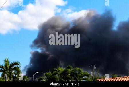 Ein massiver Brand in Hialeah, FL, von einem Schrottplatz. Schwarze Rauchwolken am Himmel. Blick von einem Wohnhaus in Hialeah. Stockfoto