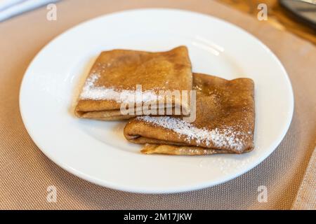 Pfannkuchen werden von oben auf einem weißen Teller gestapelt Stockfoto