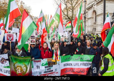 London, Großbritannien. 10.. Dezember 2022. Demonstranten halten während der Demonstration außerhalb der Downing Street die iranische Flagge und ein Banner „Women Life Freedom“. Tausende Demonstranten marschierten in Westminster und forderten Freiheit für den Iran, einen Regimewechsel und Gerechtigkeit für Mahsa Amini und andere Opfer des iranischen Regimes und forderten die britische Regierung auf, die iranische Botschaft zu schließen. (Foto: Vuk Valcic/SOPA Images/Sipa USA) Guthaben: SIPA USA/Alamy Live News Stockfoto