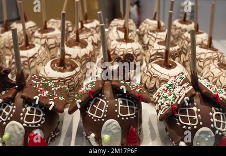 Apfel in Schokolade getaucht zu weihnachten. Toffee-Apfel, karamellisierte Äpfel mit kleinen Süßigkeiten vom Weihnachtsmarkt. Ideen für Winter, Weihnachten Stockfoto