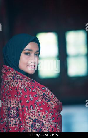 Schöne Frau in schwarzem Hijab in Batik aus Jambi, Indonesien. Stockfoto