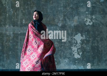Schöne Frau in schwarzem Hijab in Batik aus Jambi, Indonesien. Stockfoto