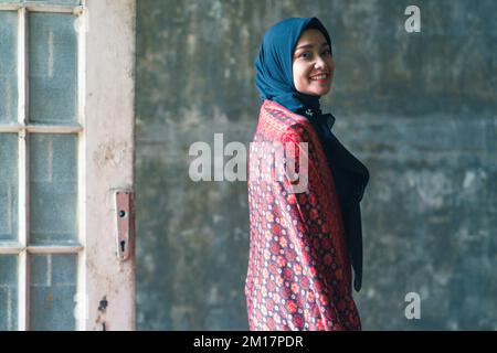 Schöne Frau in schwarzem Hijab in Batik aus Jambi, Indonesien. Stockfoto