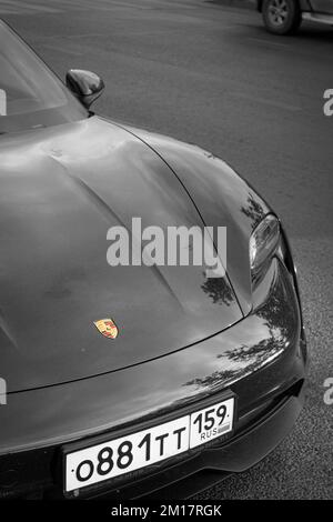 Eine Vertikale von Porsche, die auf der Straße geparkt ist, in Graustufen aufgenommen Stockfoto