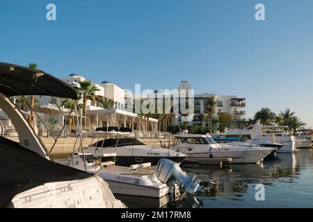 Kleine Boote, die in Dubai Creek am Park Hyatt Golf and Yacht Club festgemacht sind. Jachthafen eines mediterranen Luxushotels. Sonniger Tag in den Vereinigten Arabischen Emiraten. Stockfoto