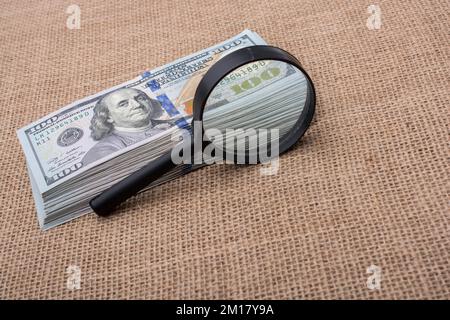 Lupe über dem Banknotenbündel aus US-Dollar Stockfoto