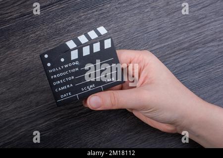 Hand-Halten-Filmklapper auf dunklem Hintergrund Stockfoto