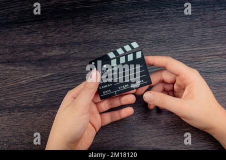 Hand-Halten-Filmklapper auf dunklem Hintergrund Stockfoto