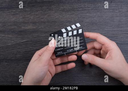 Hand-Halten-Filmklapper auf dunklem Hintergrund Stockfoto