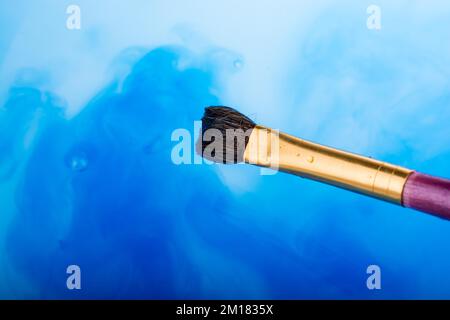 Aquarellfarbe in Wasser auflösen, wie Malerei Pinsel Wasser berührt Stockfoto