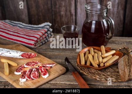 Fuet, Espetec, Secallona oder Petador, typisch katalanische Wurst, die in ganz Spanien auf der Grundlage von Schweinefleisch, Speck und Pfeffer serviert wird, begleitet von Brot. Stockfoto