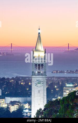 Ein vertikaler Blick aus der Vogelperspektive auf den Sather Tower bei Sonnenuntergang mit Golden Gate Bridge im Hintergrund Stockfoto