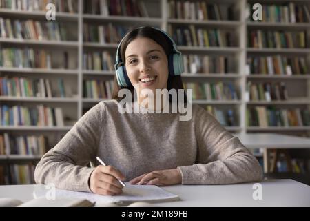 Glückliches College-Mädchen mit kabellosen Kopfhörern, Kopfschuss-Porträt Stockfoto