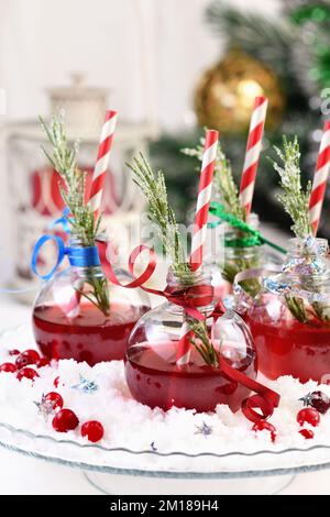 Gin mit Tonic und Preiselbeersaft. Der Cocktail ist voller festlicher Weihnachtsaromen. Serviert in transparenten Schüsseln mit einem Zweig Rosmarin. Stockfoto