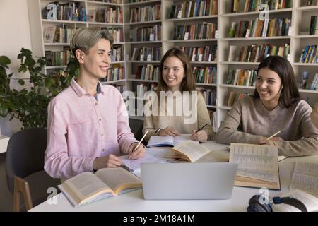 Fröhliche, glückliche Schüler treffen sich in der Highschool-Bibliothek Stockfoto