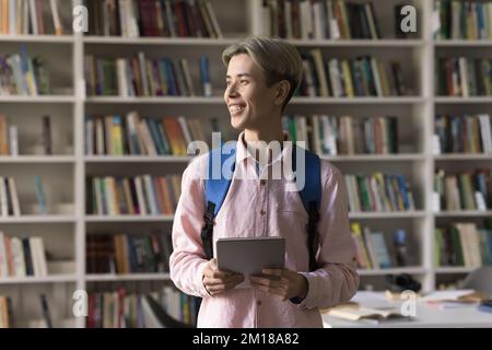 Ein fröhlicher asiatischer Teenager-Schüler mit einem digitalen Tablet Stockfoto