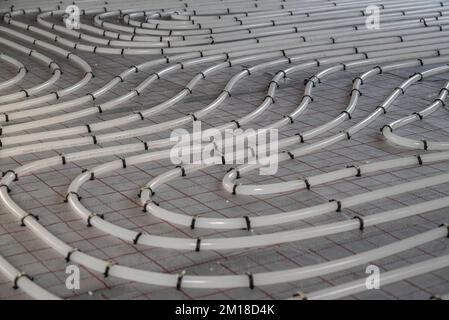 Die Wicklungsrohre der Hydronic-Heizungsanlage auf dem Boden Stockfoto