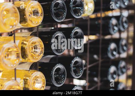 Flaschen Wein im Keller. Flaschen Weiß- und Rotwein im Keller des Weinguts. Luxuriöse Weinsammlung. Hintergrund für alkoholische Getränke. Weinsorte. Stockfoto