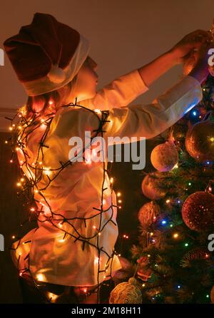 Kinder schmücken Weihnachtsbaum Stockfoto