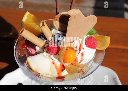 Ein Joghurtsundae mit Obst und Schlagsahne Stockfoto