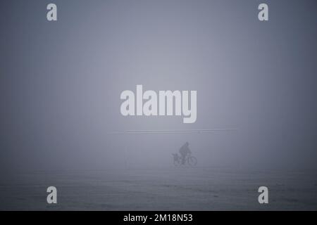 Ein Radfahrer auf Hackney Marshes in London. Schnee und Eis haben sich über Teile Großbritanniens ausgebreitet, und die kalten Winterbedingungen werden tagelang anhalten. Foto: Sonntag, 11. Dezember 2022. Stockfoto