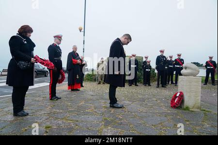 Stellvertretender Oberbürgermeister von Portsmouth, Stadtrat Tom Coles verbeugt sich, nachdem er während einer Zeremonie an der Cockle-Statue in den Rosengärten in Southsea einen Kranz gelegt hat, um die Razzia der Cockleshell-Helden zu feiern. Vor 80 Jahren verließen 12 Royal Marine Commandos Portsmouth, um eine gewagte Mission im Schutz der Dunkelheit im Hafen von Bordeaux zu vollenden. Ihre Mission war es, mit dem Kanu 70 Meilen den Fluss Gironde hinauf nach Bordeaux zu fahren und Lampenminen zu benutzen, um Schiffe zu versenken, die sich darauf vorbereiten, die neueste deutsche Ausrüstung nach Japan zu bringen. Es gab nur zwei Überlebende. Die Razzia wurde berühmt durch den Film "die Cockleshell-Helden" aus dem Jahr 1955. Bild Stockfoto