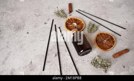 Zitrusrebendiffusor mit Zimt, trockenen Orangen- und Tannenbaumen. Parfum für Zuhause. Trendkonzept, natürliche Materialien. Stockfoto