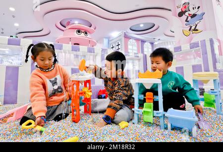 ZHANGYE, CHINA - 11. DEZEMBER 2022 - Kinder spielen fröhlich in einem Kinderpark in der Stadt Zhangye, Provinz Gansu, China, 11. Dezember 2022. Stockfoto