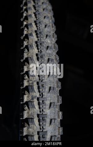 Mountainbike-Reifen auf schwarzem Hintergrund mit Kopierbereich Stockfoto