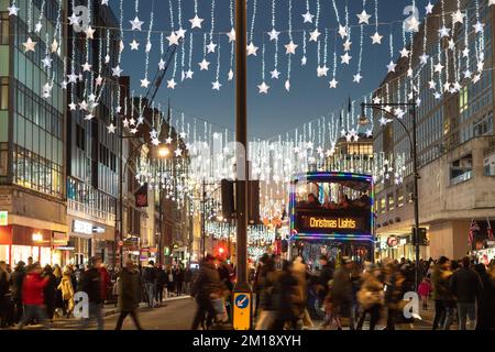 LONDON, Vereinigtes Königreich - 10.. DEZEMBER 2022: Ein Blick auf die Oxford Street in London bei Weihnachten und Nacht. Die Dekoration, die Menschenmassen und ein Weihnachtsfest Stockfoto