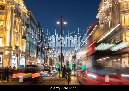 LONDON, Vereinigtes Königreich - 10.. DEZEMBER 2022: Ein Blick auf die Oxford Street in London bei Weihnachten und Nacht. Die Dekoration und der Verkehr in London. Stockfoto