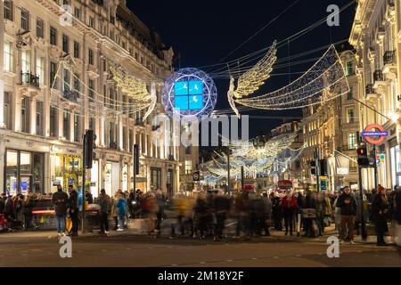 LONDON, Vereinigtes Königreich - 10.. DEZEMBER 2022: Ein Blick auf die Regent Street in London bei Weihnachten und Nacht vom Oxford Circus. Die Dekoration und die Menschenmengen von zu zeigen Stockfoto