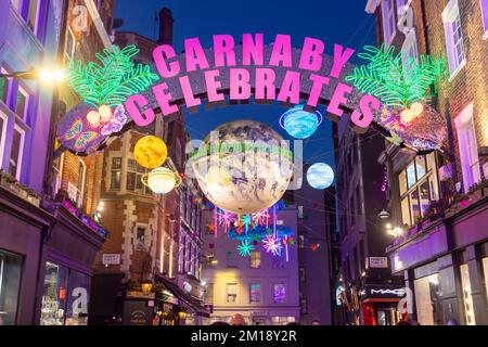 LONDON, Vereinigtes Königreich - 10.. DEZEMBER 2022: Ein weihnachtlicher Blick auf die Carnaby Street in London. Die Dekoration und Menschenmengen zu zeigen. Stockfoto