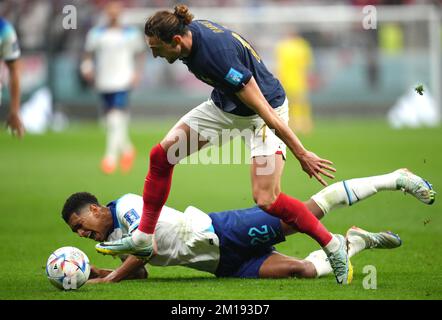 Jude Bellingham (links) aus England geht nach einem Tackle von Adrien Rabiot aus Frankreich während des Viertelfinalspiels der FIFA-Weltmeisterschaft im Al Bayt Stadium in Al Khor, Katar, unter. Foto: Samstag, 10. Dezember 2022. Stockfoto