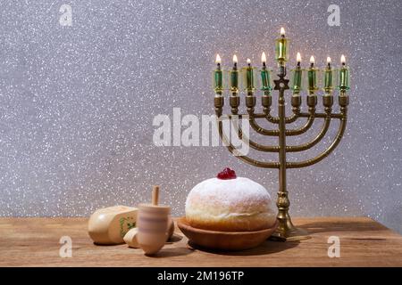 Jüdischer Feiertag Hanukka Hintergrund mit Menorah und Dreidel mit den Buchstaben Gimel und Nun. Stockfoto