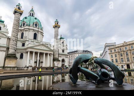 Wien, Osterreich - 14. Oktober 2022: Fassade der Karlskirche, Rektoratskirche St. Karl Borromaus oder St. Charles Church und Hill Arches von Henry Moore Stockfoto