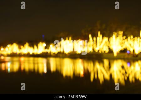 Verschwommenes Licht von Dekorationslicht auf dem Hintergrund und der Textur des Flusses Stockfoto