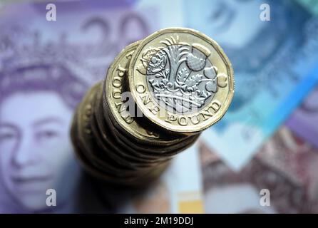 EIN HAUFEN BRITISCHER 1-PFUND-MÜNZEN AUF BRITISCHEN BANKNOTEN ÜBER DIE WIRTSCHAFTLICHE REZESSION INFLATION GELDAUSGABEN ETC. UK Stockfoto