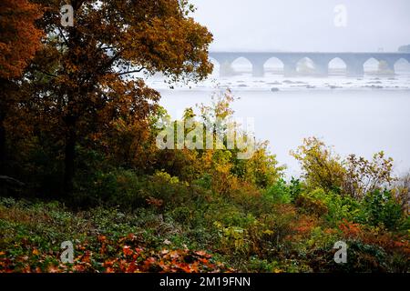 Herbstblick über die Rockville Bridge am Susquehanna River in der Nähe von Harrisburg, Pennsylvania, USA; Eisenbahnbrücke; Die längste Steinbogenbrücke der Welt. Stockfoto