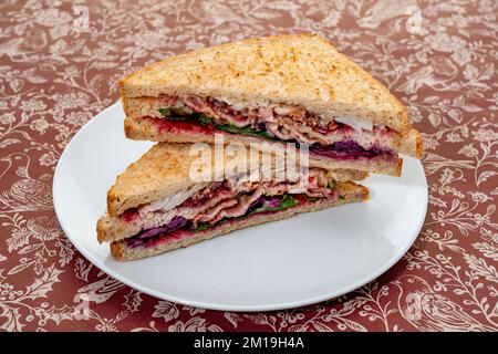 Weihnachtliche Würstchen mit putenbraten, Speck, Füllung, Rotkohl und roter Johannisbeermarmelade Stockfoto