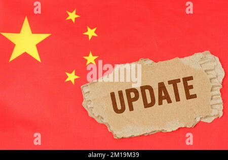 Geschäfts- und Finanzkonzept. Vor dem Hintergrund der chinesischen Flagge liegt Pappe mit der Inschrift - Update Stockfoto
