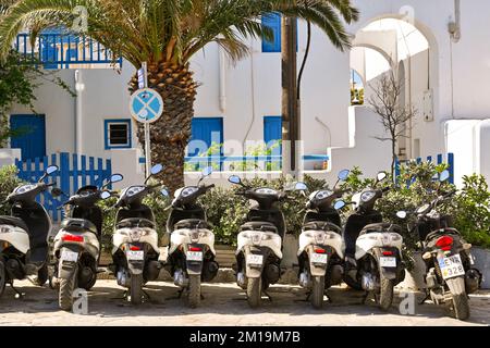 Mykonos, Griechenland - Juni 2022: Eine Reihe Motorroller steht im Zentrum der Stadt. Keine Menschen. Stockfoto