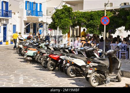 Mykonos, Griechenland - Juni 2022: Eine Reihe Motorroller parkt vor einem Restaurant im Stadtzentrum. Stockfoto