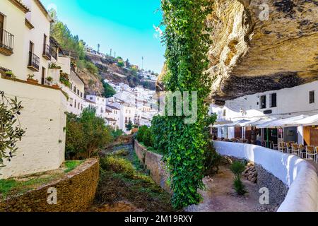 Weiße Häuser neben dem Bach und dem Berg, wo die Häuser in den Felsen gegraben werden, Setenil de las Bodegas, Cadiz. Stockfoto