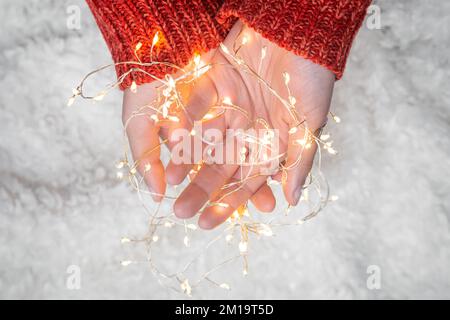 Nahaufnahme, verwickelte Girlande in weiblichen Händen, Draufsicht. Stockfoto