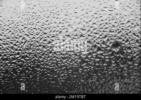 Große Tau-Tropfen auf dem Fenster nach Kondensation auf dem Fenster, Textur von Wassertropfen auf dem Glas. Stockfoto