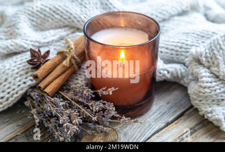 Nahaufnahme von Kerzen, Zimtstangen und Lavendel. Stockfoto